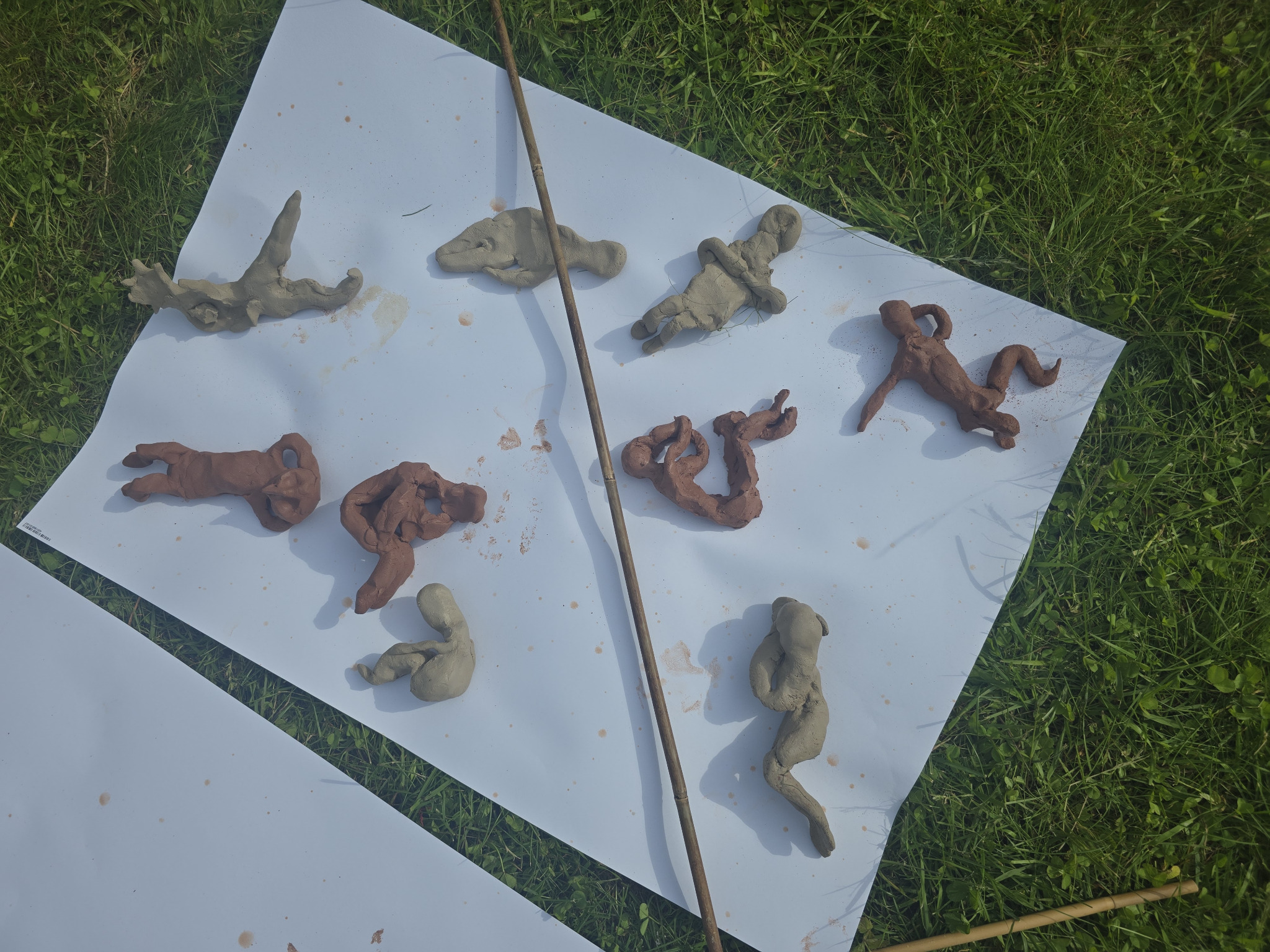 A population of small clay self-figures in different physical positions on the forest floor