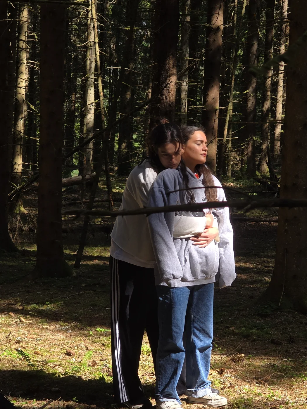 Actors together in a sunlit forest rehearsal